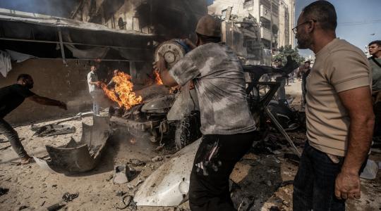 فلسطينيون يحاولون إخماد حريق في مركبة دمرتها غارة جوية إسرائيلية جنوب مدينة غزة، 22 أكتوبر/تشرين الأول